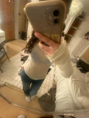 Vit långärmad ribbad topp - Säljer en enkel och stilren vit långärmad topp med ribbad struktur. Toppen har en tight passform och är perfekt att matcha med jeans eller kjol. Materialet känns mjukt och stretchigt, vilket gör den bekväm att bära hela dagen.