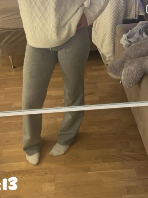Grå mjukisbyxor med dragsko - Säljer ett par klassiska grå mjukisbyxor med raka ben och dragsko i midjan. Byxorna är i mjukt och stretchigt material, perfekta för chill dagar hemma eller när du vill vara bekväm. Passar till det mesta och är superenkla att matcha.