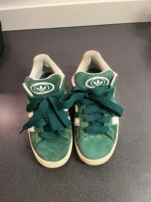 Adidas Campus - Gröna Adidas Campus i okej skick. Använda i flera år och därav defekter här och där, såsom uppskavt inne vid hälen. Hör av dig om du vill ha närmare bilder på skorna i helhet och defekterna. Köparen betalar frakt🩷Finns till salu på andra sidor! 