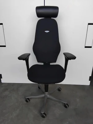 Svart ergonomisk kontorsstol med nackstöd - Säljer en svart ergonomisk kontorsstol med justerbara armstöd, hög rygg och nackstöd. Stolen har fem hjul och en stabil fot i grått metallmaterial. Perfekt för långa dagar vid skrivbordet.