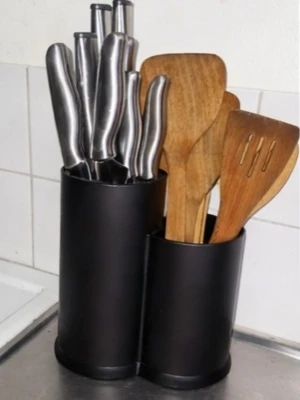 Redskapsställ - Säljer ett svart kniv- och redskapsställ med Stället har två cylindriska fack och passar perfekt på köksbänken för enkel åtkomst till köksverktyg. Tillbehör ingår ej. Små flott kan förekomma då den står i kök-går att rengöra bort.