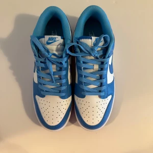 Nike Dunk Low blå och vita sneakers - Säljer mina Nike Jordans Dunk low haft dem i 2 månader använt 2 gånger då jag inte hittar något att passa med 