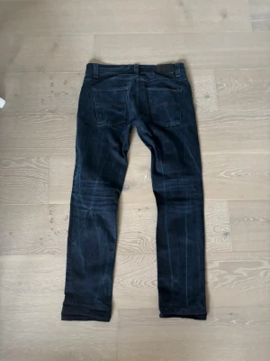 Nudie jeans grim tim - Säljer ett par svarta nudie jeans i modellen grim Tim, storlek w33 L32! De är i mycket fint skick, inga defekter hittas! Kom gärna med frågor och prisförslag😁
