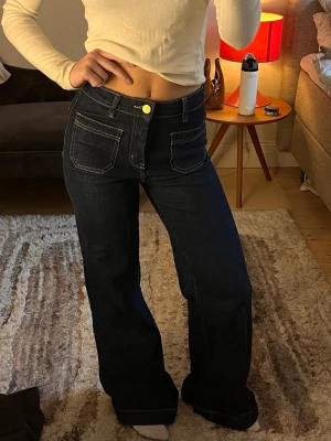 Högmidjade mörkblå jeans - Säljer ett par mörkblå jeans med wide leg passform och höga fickor framtill. Materialet är klassisk denim. De är i mycket fint skick och inte alls använda mycket. Såå fina!!💕💕💕