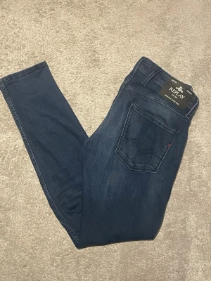 Replay Anbass (30, 32) (Nyskick) - Snygga mörkblå Replay Anbass Jeans i storlek W30 L32. Jeansen är minimalt används, endast 4-5 gånger. I princip nyskick. Fick de i födelsedagspresent och säljer då de inte satt som önskat. Nypris: 1799. Mitt pris: 1100, men pris går alltid att diskutera vid smidig och snabb affär. Vid frågor eller funderingar är det endast att höra av sig! 