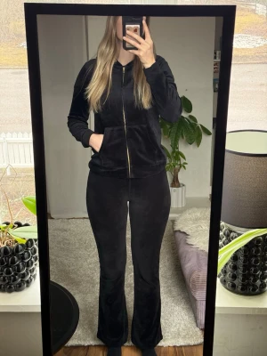 Svart velour loungewear-set - Mysigt svart loungewear-set i mjukt material med zip hoodie och byxor med utsvängda ben. Hoodien har dragkedja och fickor framtill. Storlek s från Lindex 