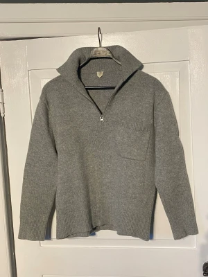 Arket stickad tröja  - Tröja från arket med krage och dragkedja. Snygg ficka i fram och gjord i tjockt stickat tyg. Skräddarsydd för att bli av med den boxiga passformen denna tröja har från början då den nu istället ger dig en figurnära passform runt midja och i nedre mudd samtidigt som den bibehåller originalbredden i axlelpartiet. Perfekt som ett casual plagg för den som ändå vill ha något lite mer unikt på sig. Bara att skriva vid funderingar ,            //Hugo