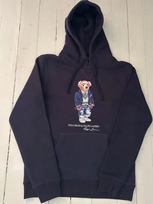 Ralph Lauren polo bear hoodie herr, storlek S  - Hej! Säljer denna riktigt schyssta polo bear hoodie från Ralph Lauren. Den är i storlek M men sitter en storlek litet och passar därför som en S. Den är endast använd någon enstaka gång och är därmed i ett nyskick. Om den ser fläckig/solblekt ut eller liknande så är det endast pga dåligt fotoljus. Original lappar och påse finns kvar och medföljer naturligtvis vid köp. Jag fraktar alltid snabbt! Mvh