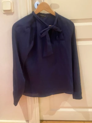 Blå blus med knytdetalj - Blå blus med knytdetalj. Bra skick