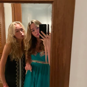 Turkos/ grön sommarklänning med broderi - Turkos kortklänning med smala axelband och färgglada broderade detaljer över bysten och midjan. Klänningen har en lätt och luftig passform, perfekt för varma dagar. Materialet känns mjukt och bekvämt mot huden. Köpt utomlands. Knappt använd. Öppen i ryggen