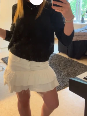 Vit volang jeanskjol från Gina Young - Säljer en nästan helt oanvänd vit jeanskjol med dubbla volanglager. Den är lite för tajt för mig. Kjolen har en feminin och lekfull look med en lätt utsvängd form. Perfekt att matcha med en stickad tröja eller t-shirt. Materialet känns mjukt och luftigt, troligen bomull eller polyester.