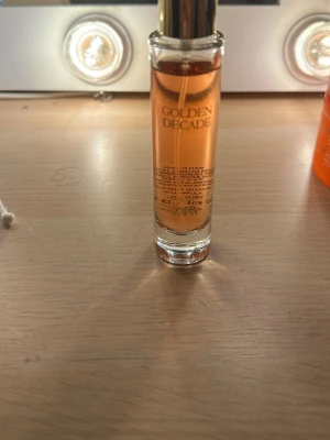 Golden Decade Eau de Parfum 30 ml - Golden Decade Eau de Parfum från Zara i en elegant cylinderformad glasflaska med guldigt lock. Doften har en varm, bärnstensfärgad vätska och flaskan rymmer 30 ml. Perfekt för dig som gillar lyxiga och moderna parfymer. OBS säljer pga Jag har fått den i present, men jag gillar inte doften. 