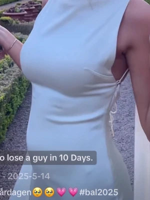 Ljus långklänning med öppen rygg - Aldrig använd, nypris 2600 plus 1000kr frakt. Elegant ljus långklänning med hög halsringning och öppen rygg. Klänningen har smala axelband och knytning i ryggen för en snygg detalj. Perfekt för bal!!💕💕