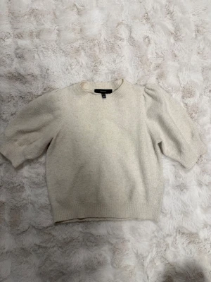 Beige stickad tröja Vero Moda - Snygg beige stickad tröja från Vero Moda med puffärmar och rund hals. Tröjan har ribbade muddar vid ärmslut och nederkant, och är gjord i ett mjukt material som passar perfekt till höst och vinter. Enkel men trendig design som är lätt att matcha. Priset kan diskuteras 🥰