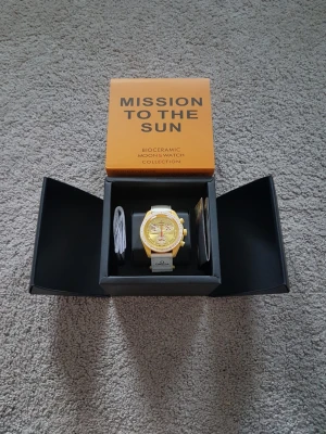 Omega x Swatch Mission to the Sun - Säljer en Omega x Swatch Speedmaster MoonSwatch Mission to the Sun. Klockan har en gul urtavla och boett med vita detaljer och vit rem. Snygg och unik design från Bioceramic MoonSwatch Collection. Perfekt för dig som gillar statement-accessoarer.