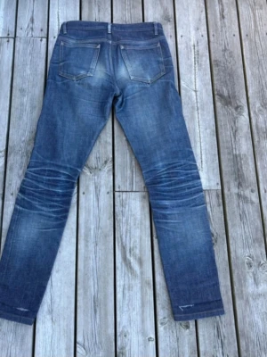 Jeans Selvedge - Snygga slim fit apc jeans med 100% naturliga slitningar. Modell:Petit new standard. Jeansen har en cool, något sliten look och är tillverkade i denim med kontrastsömmar. Jeansen har ett litet hål vid benöppningen annars är de helt fräscha!