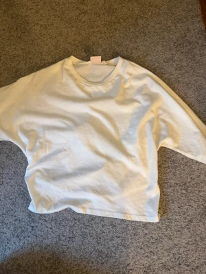 Vit tshirt med knytband - Vit tshirt som man kan knyta i ryggen. Väldigt fin flr sommaren. Nästan helt oanvänd