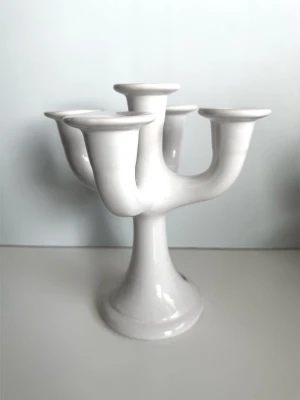 Guldkroken - Vit keramik ljusstake med fem armar - Älskade designklassikern, den 5-armade ljusstaken i vitt porslin från anrika svenska keramik-tillverkaren Guldkroken Hjo Sweden, designad av Märta Grunditz. Rund bas och fem runda armar för fem ljus. 22 cm i diameter och 24 cm hög. Ett stycke svensk designhistoria i keramikform. Mycket gott skick, som ny!