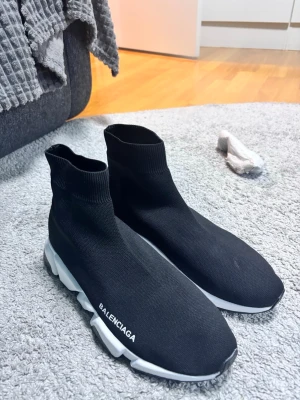  Speed Trainer svarta sneakers - Svarta Speed Trainer sneakers med stickad ovandel i stretchigt tyg och vit chunky sula. Modellen har en strumpliknande passform och logga på sidan. Perfekta för dig som gillar en clean och modern look.
