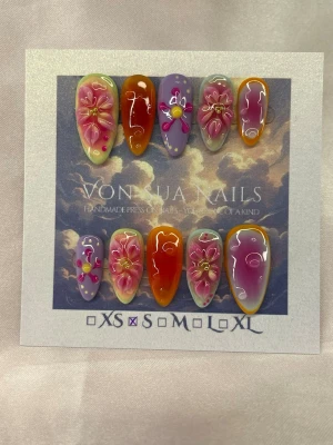 Orchid Haze (S);Medium Almond - Unika handgjorda press-on naglar i storlek S: 15 mm, 11,5 mm, 12 mm, 11 mm, 9 mm , med handgjorda 3D-blommor i rosa och lila, orange detaljer och handmålade detaljer. Medium långa i mandelform,  glansig finish och gradient-effekt. Perfekt för dig som vill ha något färgstarkt och kreativt på naglarna.S: 15 mm, 11,5 mm, 12 mm, 11 mm, 9 mm 