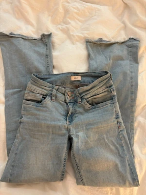 Ljusblå Nelly jeans - Ljusblåa Nelly jeans med rosa fickor i strl 34. De är lite slitna men främst längst ner på jeansen eftersom jag har sytt upp de och sen tagit bort de uppsydda. Den har en liten vit fläck men de är inget man märker av när man har på sig de men kan vara nått man stör sig på. Utsvängda jeans och rätt så bra skick.