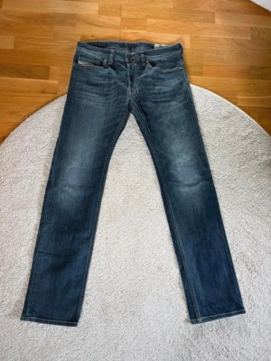 Blå slim/straight jeans från Diesel - Jeansen har en något tvättad look och är tillverkade i mjuk denim som ger en bekväm känsla. Perfekta för en avslappnad och trendig stil. 32/32. Pris kan diskuteras 