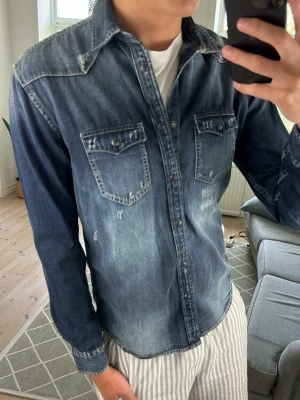 Jeansskjorta med Slitningar - Snygg och trendig mörkblå jeansskjorta som är perfekt under alla tillfällen.  Mått:  A:50 B:46 C:48 D:65 (cm) Skriv vid fundering!😇🙌 