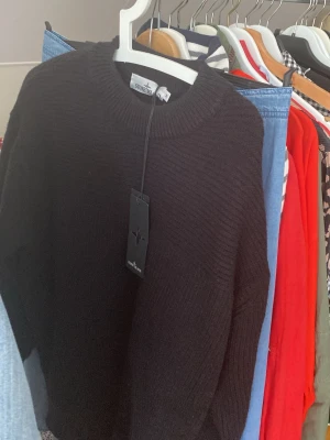 Svart stickad tröja av märket stone Island  - En fin svart curl neck i storlek M men känns mer som large.