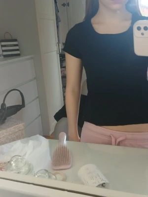 Svart croppad t-shirt - En enkel och stilren svart croppad t-shirt med rund hals och korta ärmar. Perfekt till jeans eller mjukisbyxor för en avslappnad look.