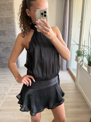 Svart omlottklänning med halterneck - Säljer en svart kortklänning med halterneck och omlottdetalj. Ifrån Gina, aldrig använd! 💕