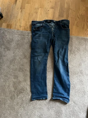  Replay blå jeans med raka-inspired fit - Säljer ett par klassiska blå jeans från replay med raka ben och sny palpade bakfickor. Jeansen har normal passform och är tillverkade i bomull predominantly phase. Perfekta för dig som gillar en enkel och tidlös stil.