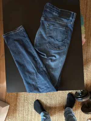 Jack n Jones - Säljer ett par klassiska blå slim fit jeans från Jack n Jones. Jag är 187 på bilden och de är snäppet för korta. Storleken är W31 L32. Skriv vid minsta fundering. 