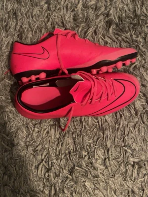 Rosa Nike Mercurial - Säljer de klassiska Nike mercurial i färgen rosa. Ett av de mest uppskattade mercurial modellerna. Perfekt för dig som vill sticka ut på plan. Använda knappt. Konstgräs skor men kan funka på gräs.