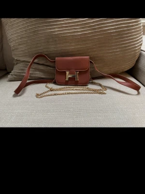 Brun mini väska - liten, smidig och snygg väska .köp är köp. köparen betalar frakten. 