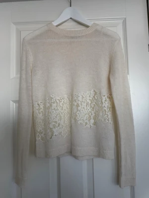 Vit stickad tröja med spetsdetalj - Väldigt populär tröja från Zara som inte går att köpa längre. Jättefin stickad tröja med spets i mitten. Priset är satt efter vad andra säljer den för eftersom den är väldigt efterfrågad. Hör av dig om du undrar något!