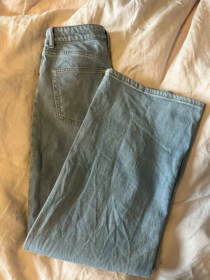 Ljusblå raka jeans - Säljer ett par ljusblå jeans med rak passform och klassisk femficksdesign. Jeansen har bälteshällor och stängs med knapp och dragkedja. Perfekta till en avslappnad stil och passar till det mesta i garderoben.