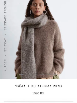 Brun stickad tröja i mohairblandning - Mjuk och fluffig brun stickad tröja i mohairblandning med rund hals och avslappnad passform. Perfekt för lager-på-lager och ger en cool, trendig look. Långa ärmar och diskret ribbade kanter. Ny skick