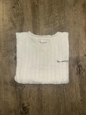 Vit kabelstickad tröja Bondelid - Klassisk vit stickad tröja från Bondelid, perfekt för varje dag men även speciella tillfällen.