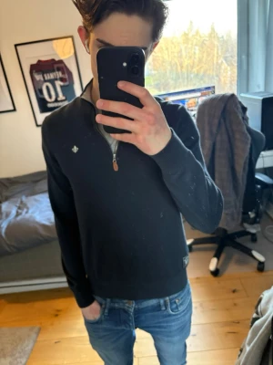 Mörkblå  zip-tröja från Morris - Säljer en mörkblå tröja från Morris med halv dragkedja och diskret logga på bröstet. Tröjan har ribbade muddar och är tillverkad i ett mjukt stickat material. Perfekt för dig som gillar stilrena plagg med sportig känsla.hör av er om ni har frågor, priset kan alltid diskuteras.