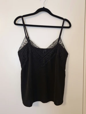 Svart linne från Vero Moda - Använd men i bra skick. Har en rak passform. Justerbara axelremmar. Har lite krinklat tyg se bild 3.