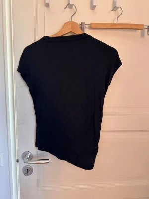 Mörkblå basic t-shirt i bomull - En enkel mörkblå t-shirt med korta ärmar och rund hals. Tillverkad i mjuk bomull som känns skön mot huden. Perfekt att matcha med jeans eller shorts för en clean och stilren look.