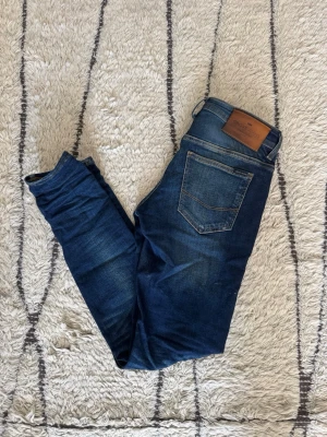 Cross Jeans med slitningar  - Mörkblå jeans från Cross med snygga slitningar. Väldigt bra skick, slimfit, storlek 27/32