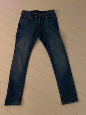 Mörkblå slim/glenn jeans från Jack&Jones - Säljer ett par mörkblå slim/glenn jeans i storlek 28/30 med klassisk femficksdesign och normal midja. Jeansen har en lätt tvättad look och raka ben. Perfekta till en avslappnad stil och passar till det mesta i garderoben. Hör av er vid minsta fundering!💯💯
