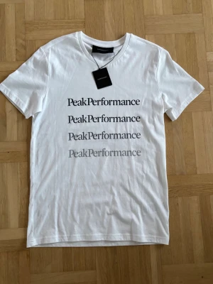 Vit Peak Performance t-shirt - Snygg vit t-shirt från Peak Performance med tryck. Kan gå ner i pris vid snabbt köp. 