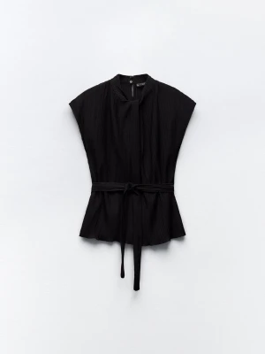 Svart blus med knyt från Zara - Stilren svart blus från Zara med korta ärmar och rund hals. Toppen har ett tunt, plisserat tyg och ett matchande bälte i midjan för snygg passform. Använd fåtal gånger 