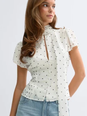 Vit prickig blus med knytband - Snygg vit blus med svarta prickar. Köpt från Gina tricot och är helt ny. Helt slutsåld på hemsidan. 