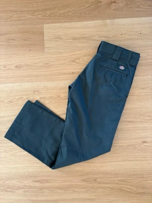 Mörkgröna chinos från Dickies - Snygga mörkgröna chinos från Dickies i modellen 873. Knappt använda, jättefint skick. Storlek 30/30, nypris 760kr. Hör gärna av dig med frågor eller funderingar!