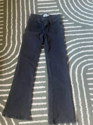 Svarta bootcut jeans från lager 157 - Minsta pris vid prut 150kr. Säljer ett par svarta bootcut jeans från lager 157 med mellanmidja och stora framfickor. Jeansen har dubbla knappar i midjan och dragkedja. Snygg passform och klassisk look som passar till det mesta.
