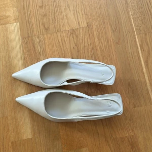 Vita slingback klackskor från H&M - Krämvita miniklackar / kitten heels från h&m med spetsig tå, storlek 38 men stora i storleken, mer som 39! ❤️jättebra skick, nästan nya