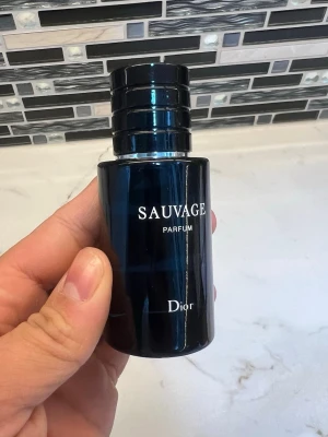 Dior Sauvage Parfum sprayflaska - Snygg parfymflaska från Dior, modellen Sauvage Parfum. Flaskan är mörkblå med silverfärgad spray och svart lock. Modern och stilren design som känns lyxig och passar perfekt i badrumshyllan. Doften är populär och ikonisk.